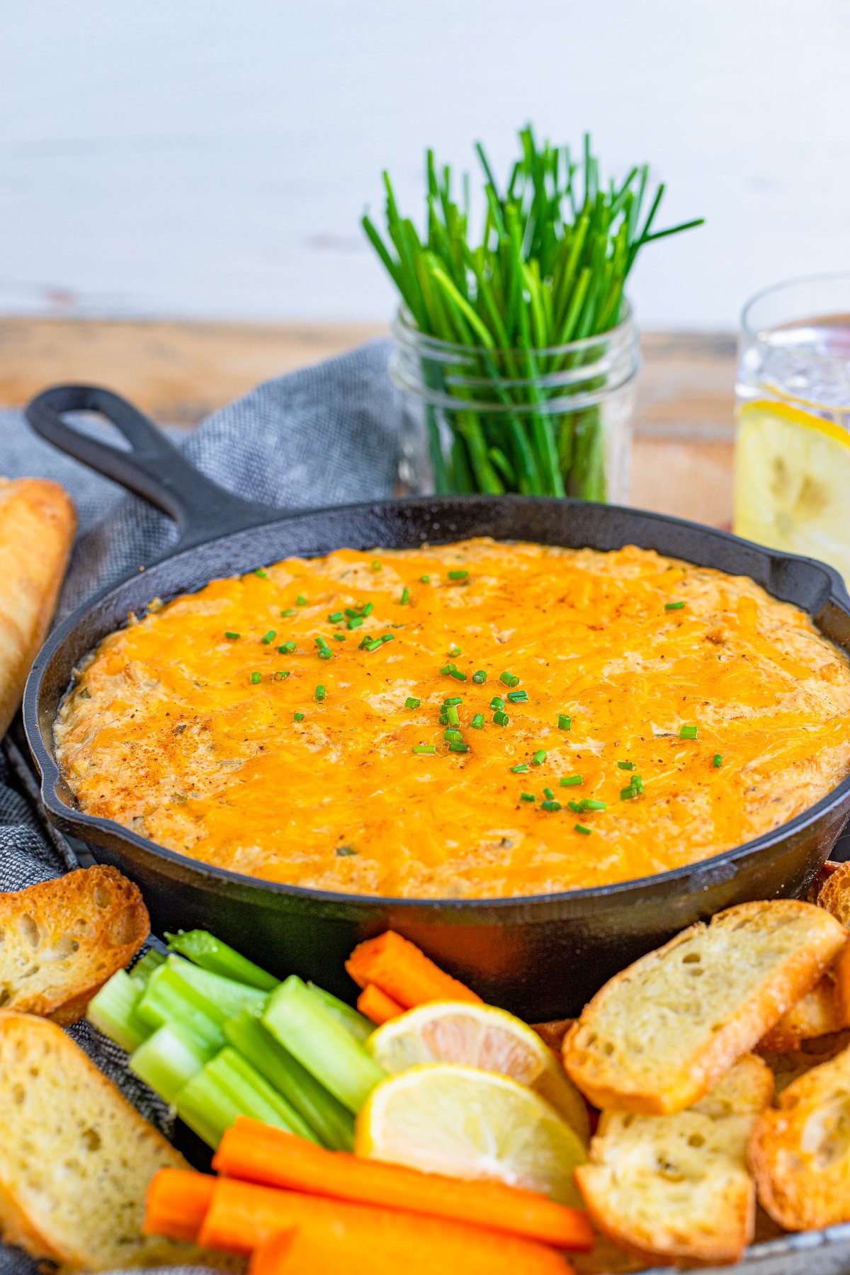 Smoked Crab Dip Recipe finished topped with chives in cast iron skillet.