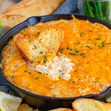 Square image of dip with two pieces of bread in dip.