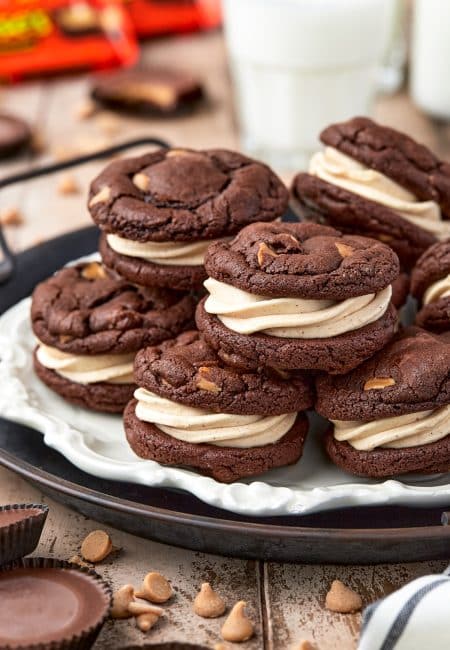 Stacked Reese's Sandwich Cookies on parchment lined round tray.