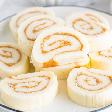 Square image of stacked and slilced Potato Candy on white plate.