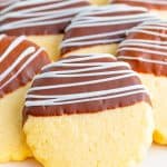 Chocolate dipped shortbread cookies drizzled with white chocolate on a plate