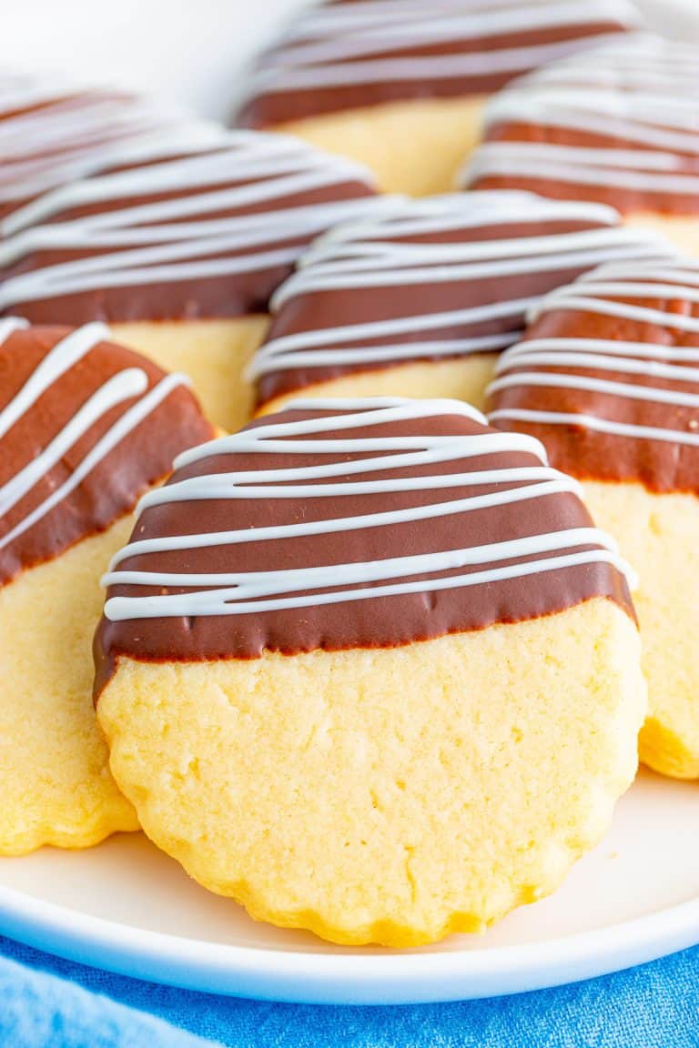Chocolate dipped shortbread cookies drizzled with white chocolate on a plate