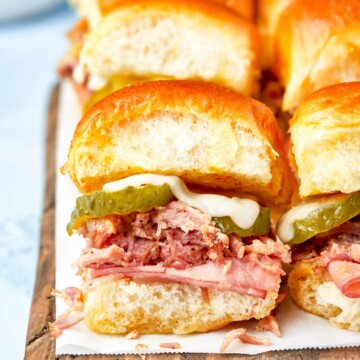 Cuban Sliders lined up on wooden board for serving.