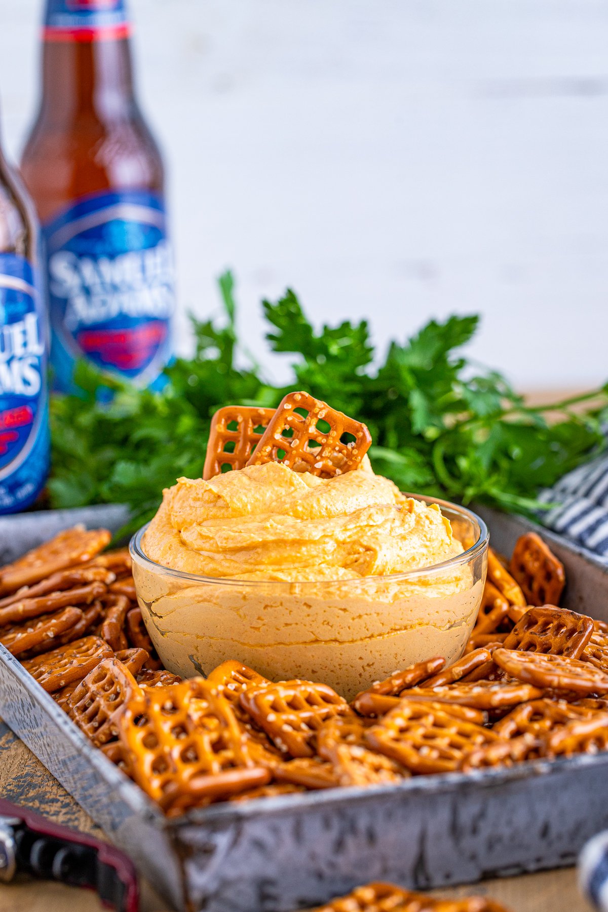 Pub Style Beer Cheese Dip surrounded by pretzels with pretzels in dip.