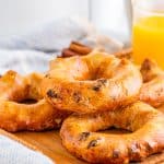 Layered Bagels on wooden board with orange juice in backgrounf.