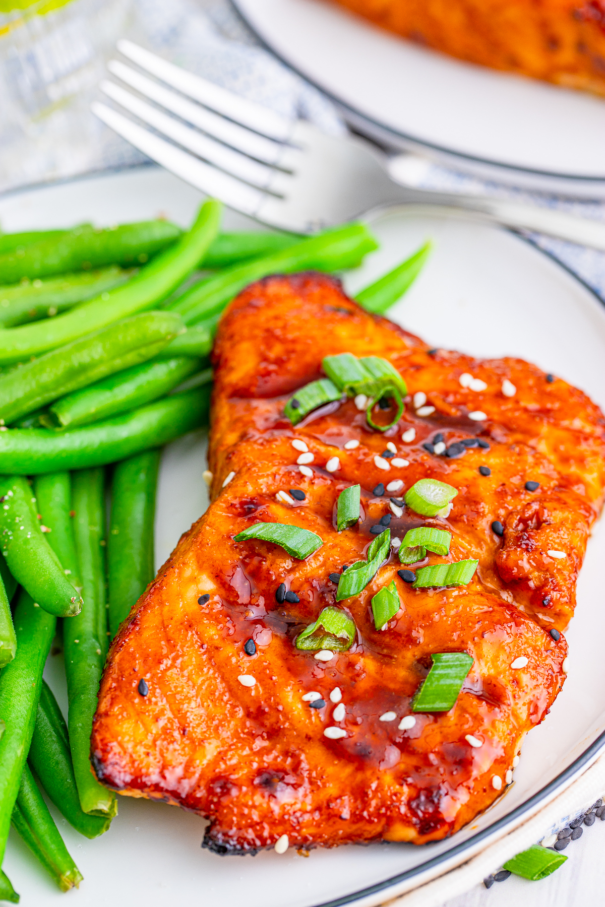 Overhead of Air Fryer Salmon Recipe showing garnishes on plate with green beans.