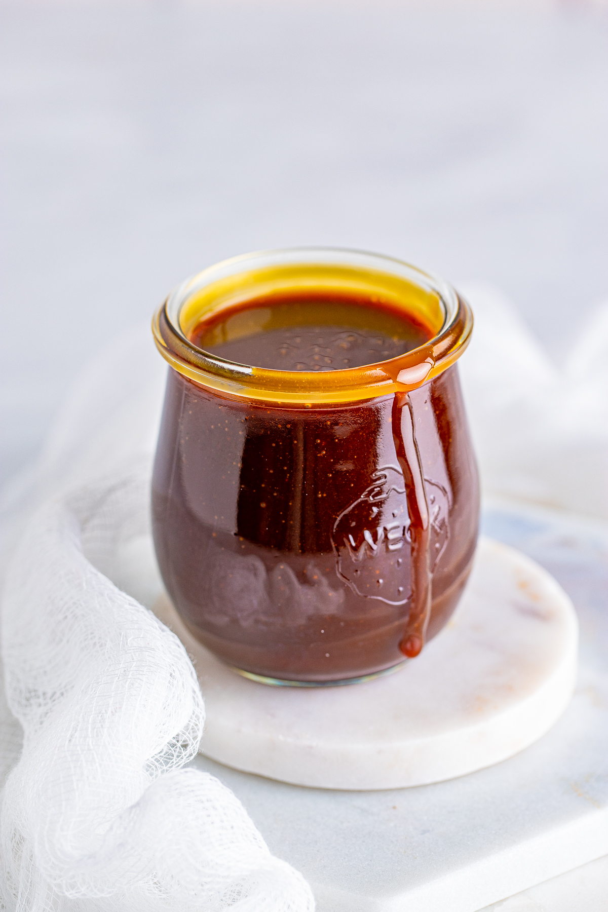 Butterscotch Sauce in clear jar with white linen.