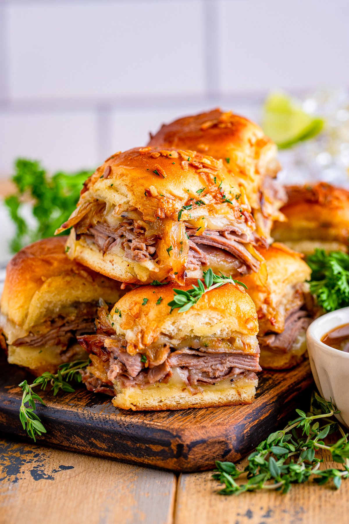 Stacked French Dip Sliders on wooden board.