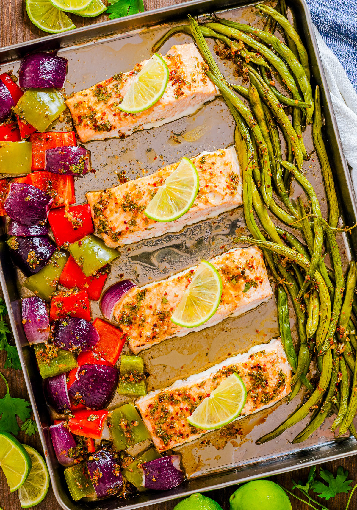 Finished Salmon Sheet Pan Dinner overhead out of oven with salmon topped with lime slices.