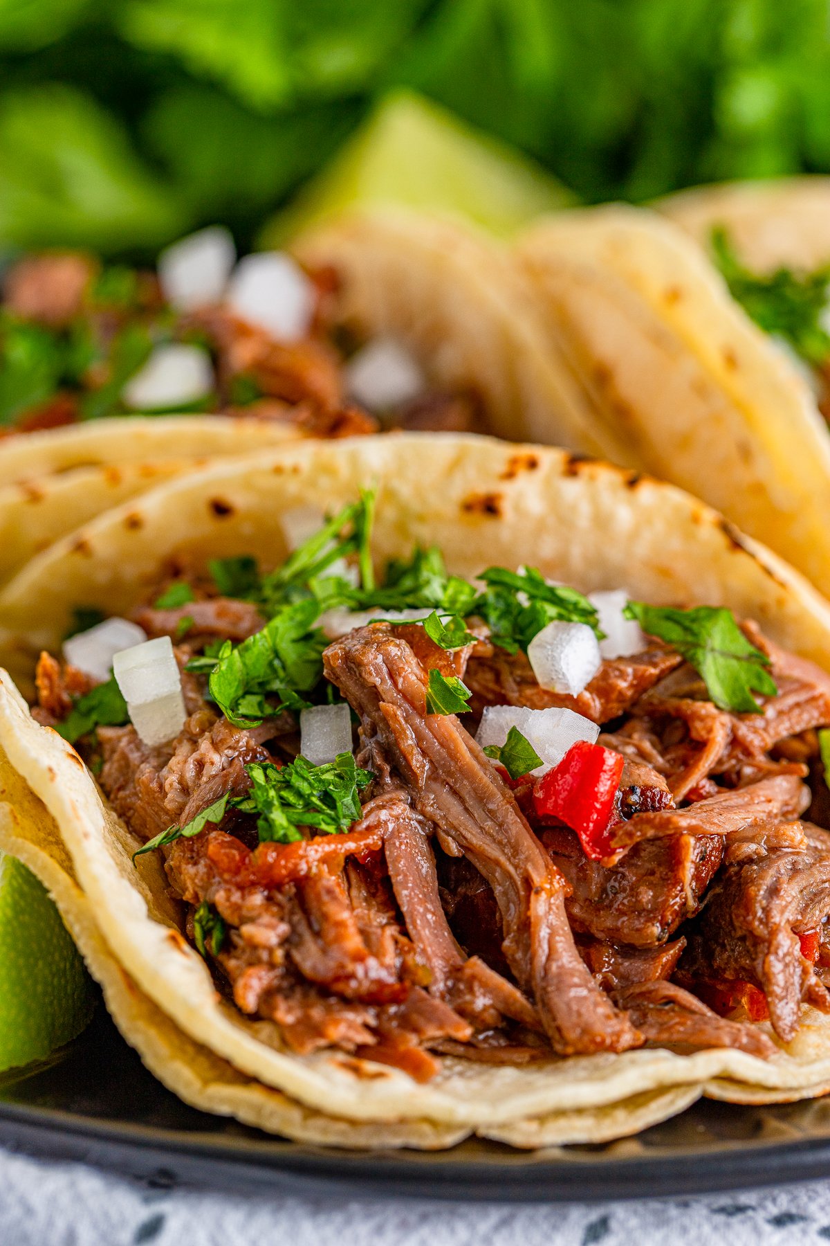 Close up of one taco showing the shredded beef for slow cooker shredded beef tacos