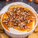 Butterscotch Cheesecake Dip in bowl with topping and cookies.