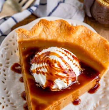 A slice of butterscotch pie topped with whipped cream and caramel drizzle.