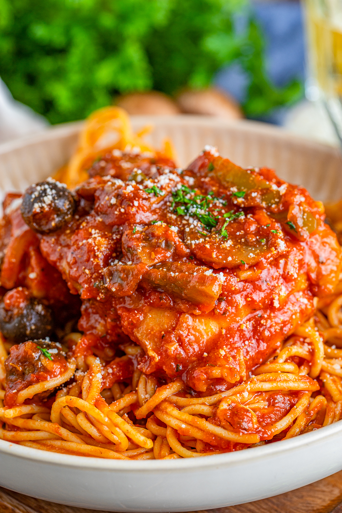 Chicken Cacciatore Recipe over spaghetti in bowl garnished.