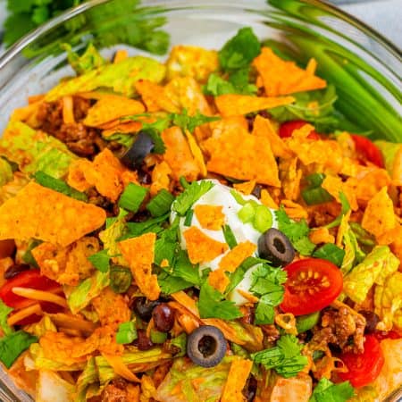 Finished salad overhead in glass bowl with toppings.