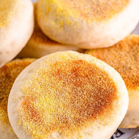 Stacked finished English Muffins on plate.