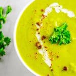 Close up overhead photo of Pea Soup in white bowl garnished.