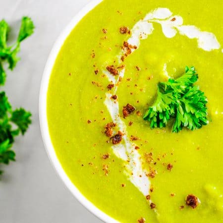 Close up overhead photo of Pea Soup in white bowl garnished.