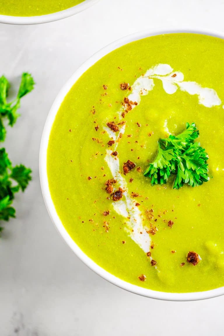 Close up overhead photo of Pea Soup in white bowl garnished.