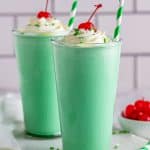 Two Shamrock Shake Recipes topped with whipped cream and a cherry.
