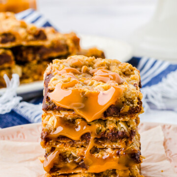 Close up of stacked Carmelitas showing caramel on pink plate.