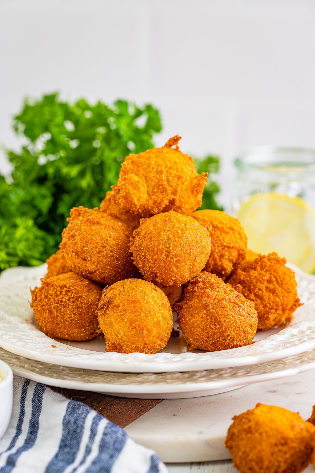 Stacked Hush Puppies on white plate.