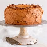 A whole frosted marble cake with chocolate frosting on a cake stand