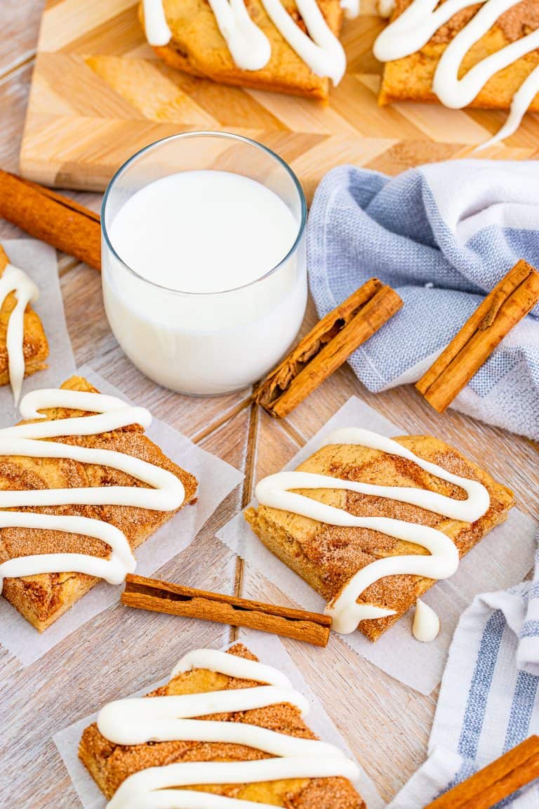 Overhead of glazed Cinnamon Roll Blondies with milk and cinnamon sticks.