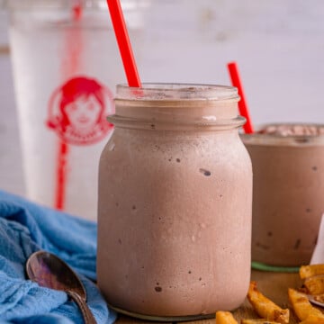 Wendy's Frosty Recipe in mason jar with fries and a water cup in background.