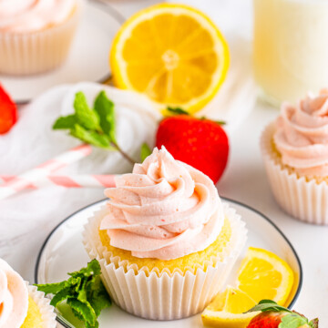 One Lemon Cupcake on plate with lemon slice and mint.