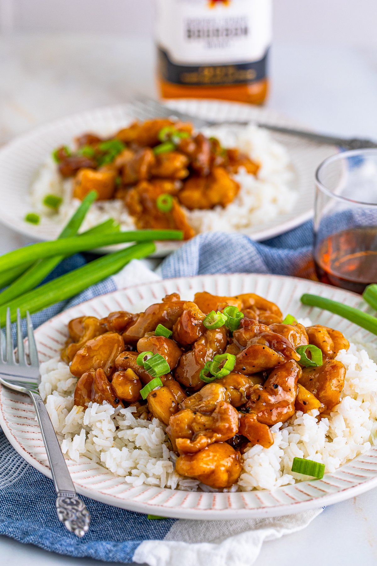 Two plate with Bourbon Chicken over rice.