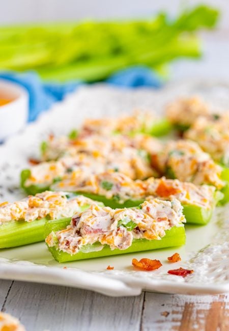 Cheddar Bacon Ranch Stuffed Celery Sticks lined up on white platter.