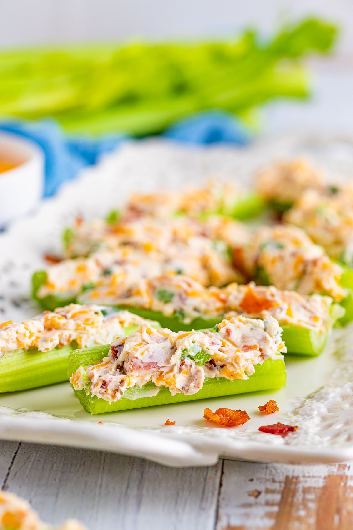 Cheddar Bacon Ranch Stuffed Celery Sticks lined up on white platter.
