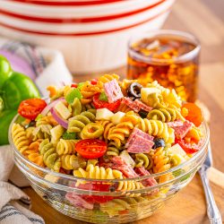 Classic Pasta Salad in bowl with tea in background.