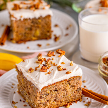 Close up of one slice of Hummingbird Cake frosted and topped with nuts.