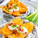 Slow Cooker Baked Potatoes on plates with toppings.