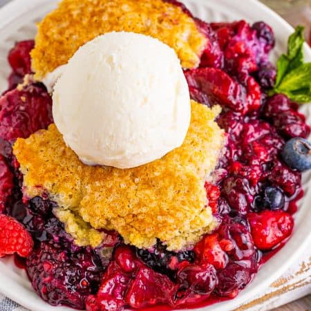 Overhead of Berry Cobbler on plate topped with ice cream.