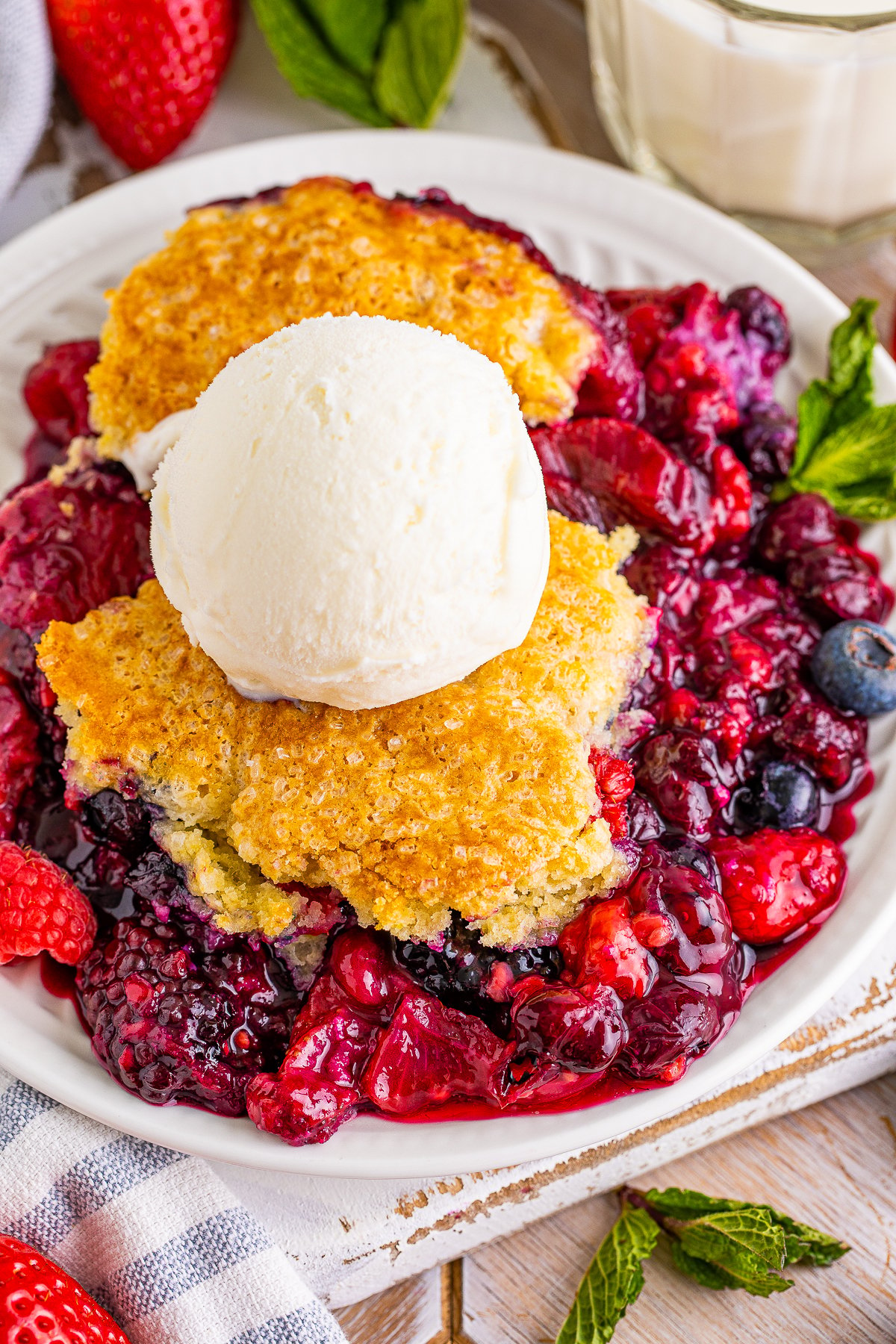 Overhead of Berry Cobbler on plate topped with ice cream.