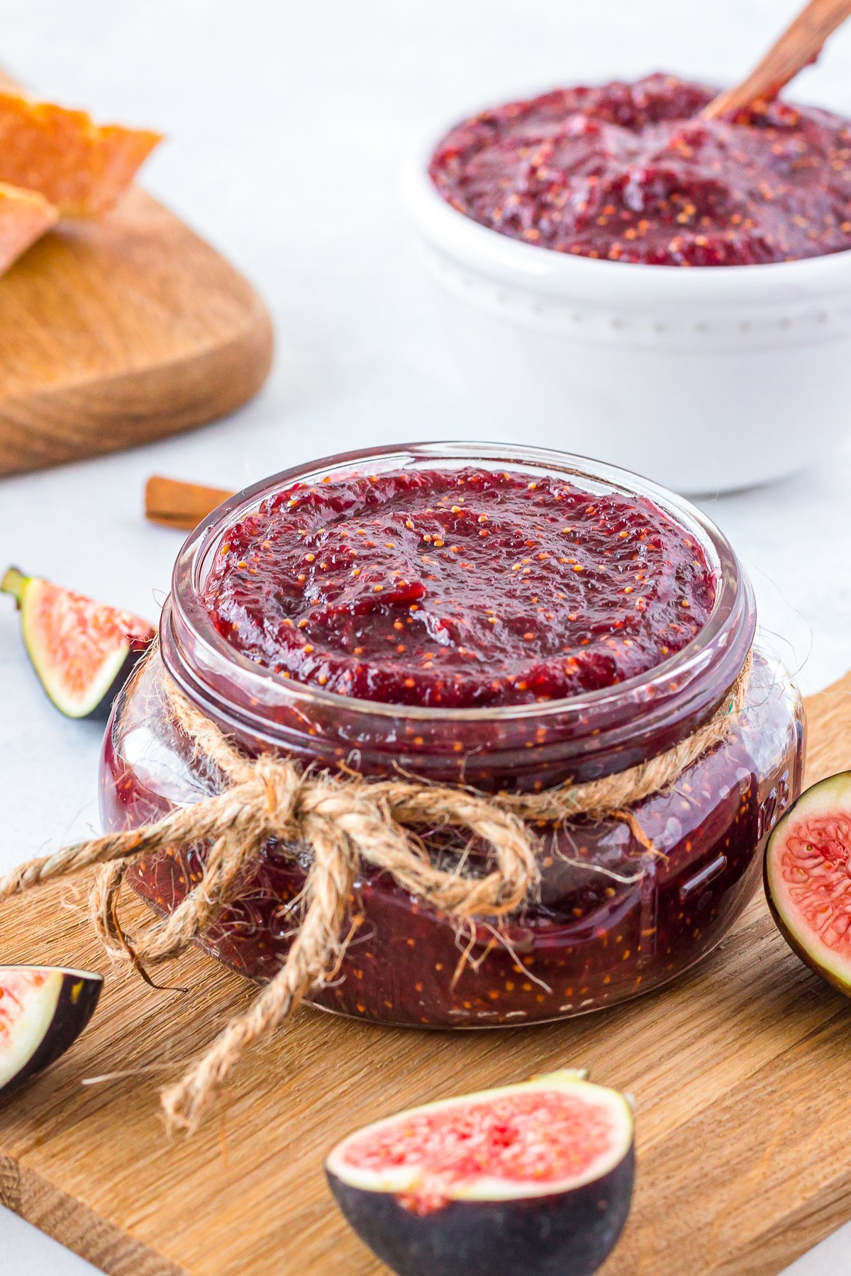 Fig Jam Recipe in a jar with string and figs cut around it.