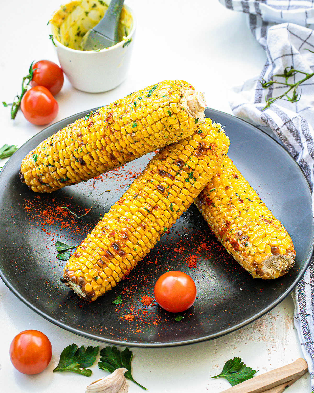 Black plate with stacked Grilled Corn.