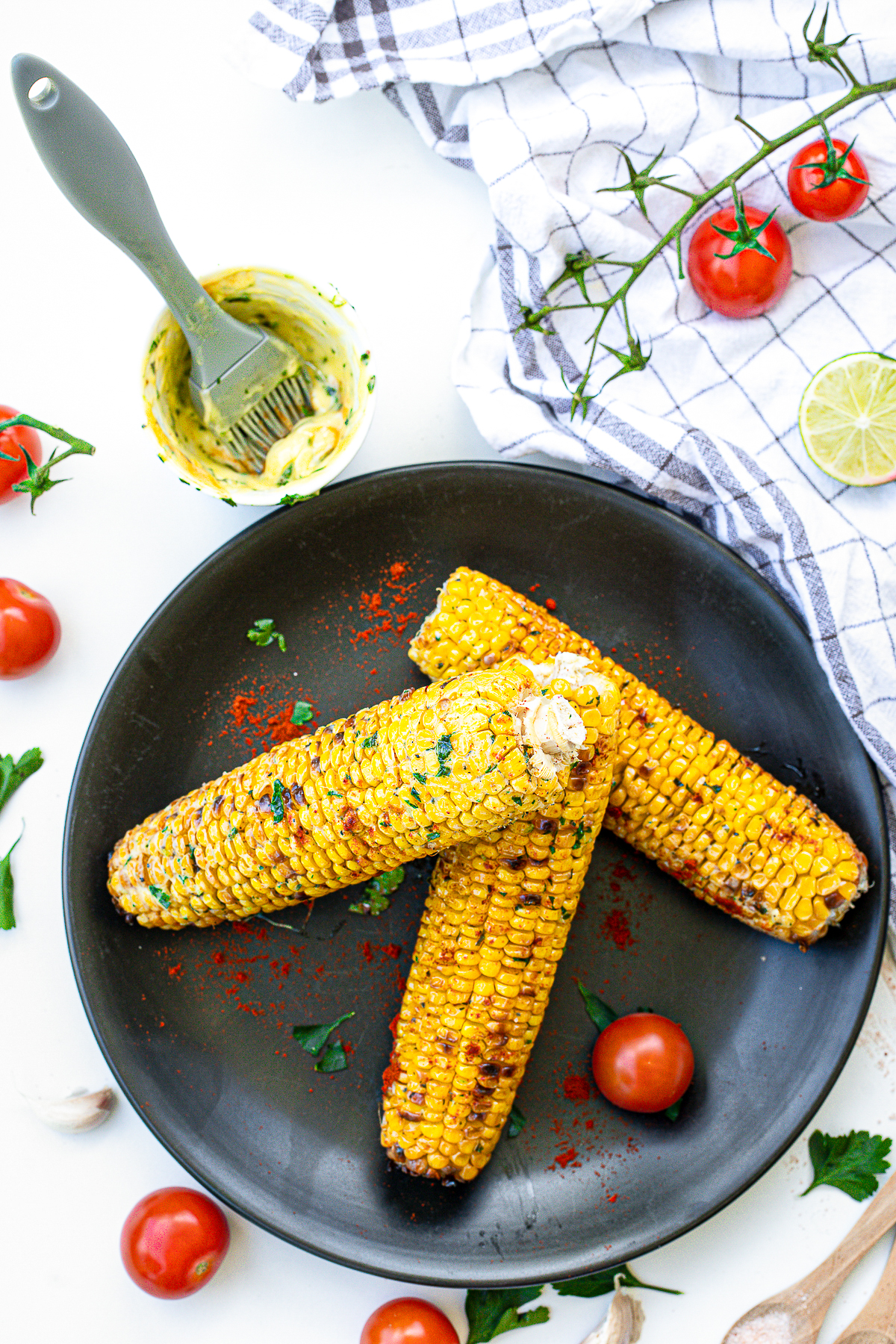Overhead photos of stacked Grilled Corn on black plate.