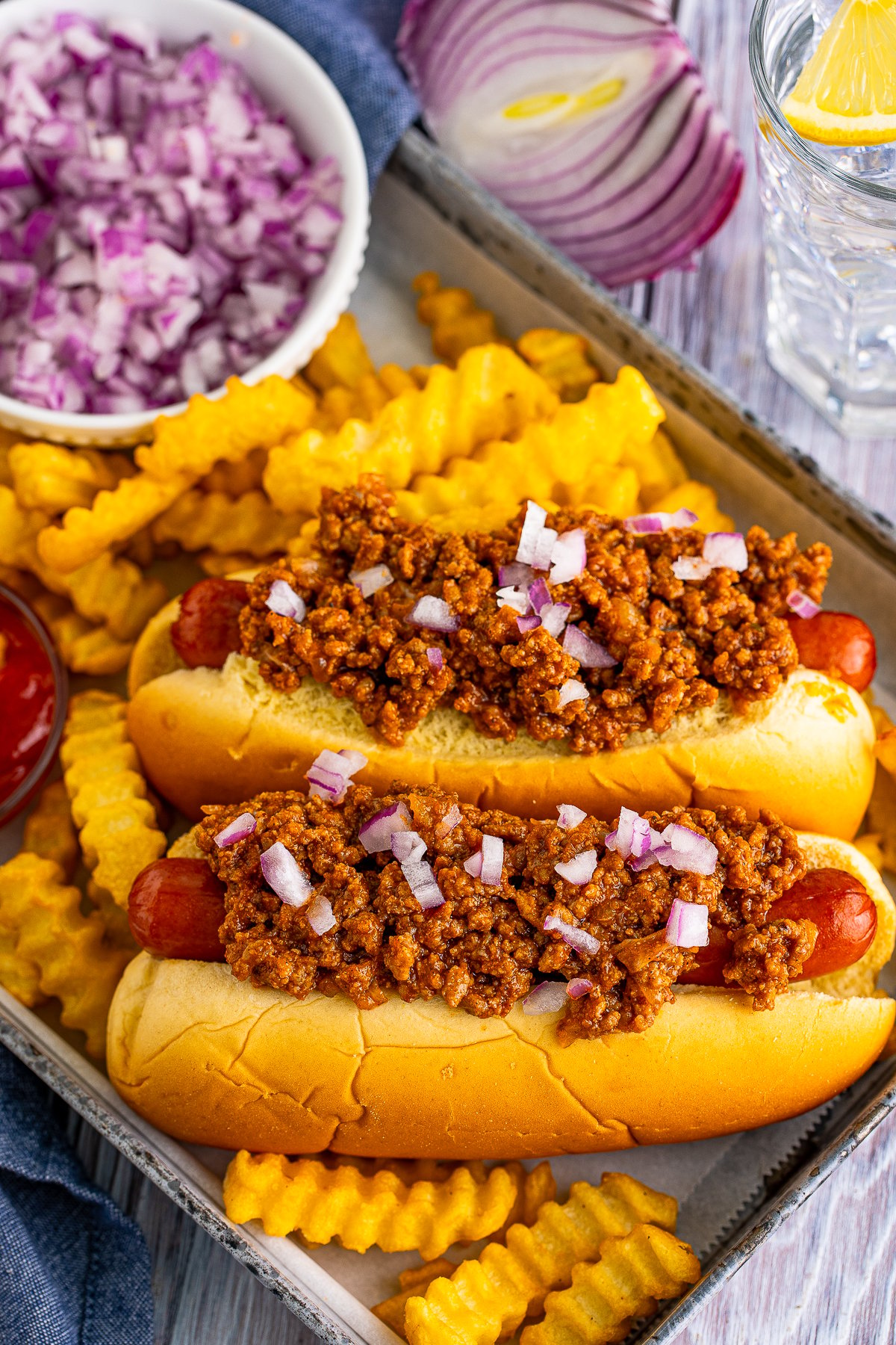 Overhead of hot dogs on platter with fries topped with New York Style Hot Dog Chili.