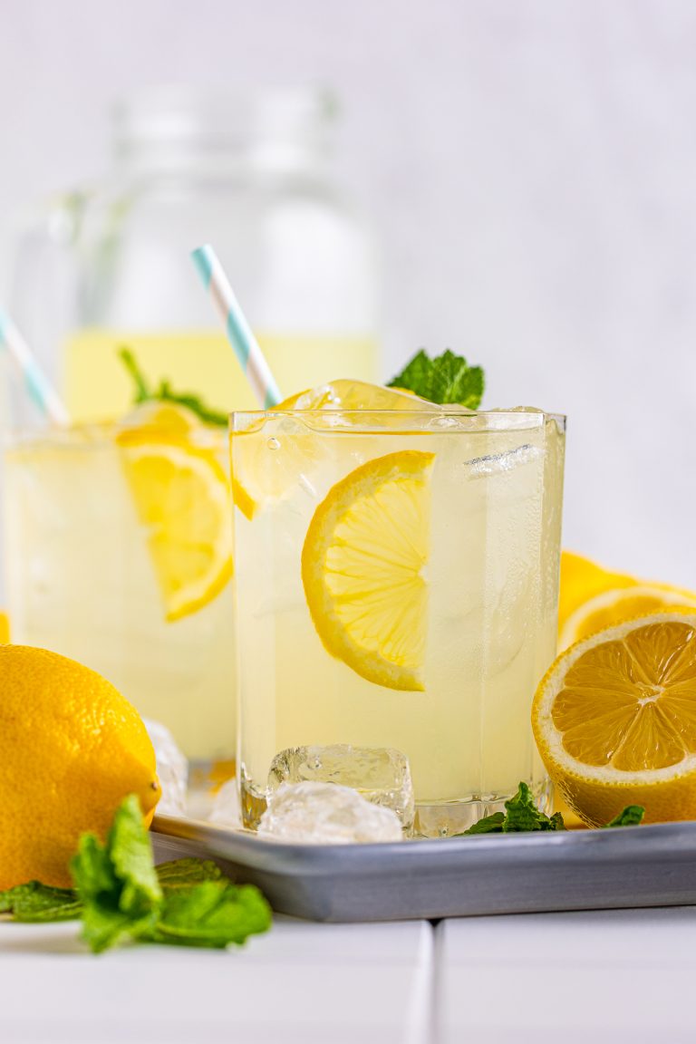 Straight on photo of Lemonade Recipe on tray with pitcher in background.