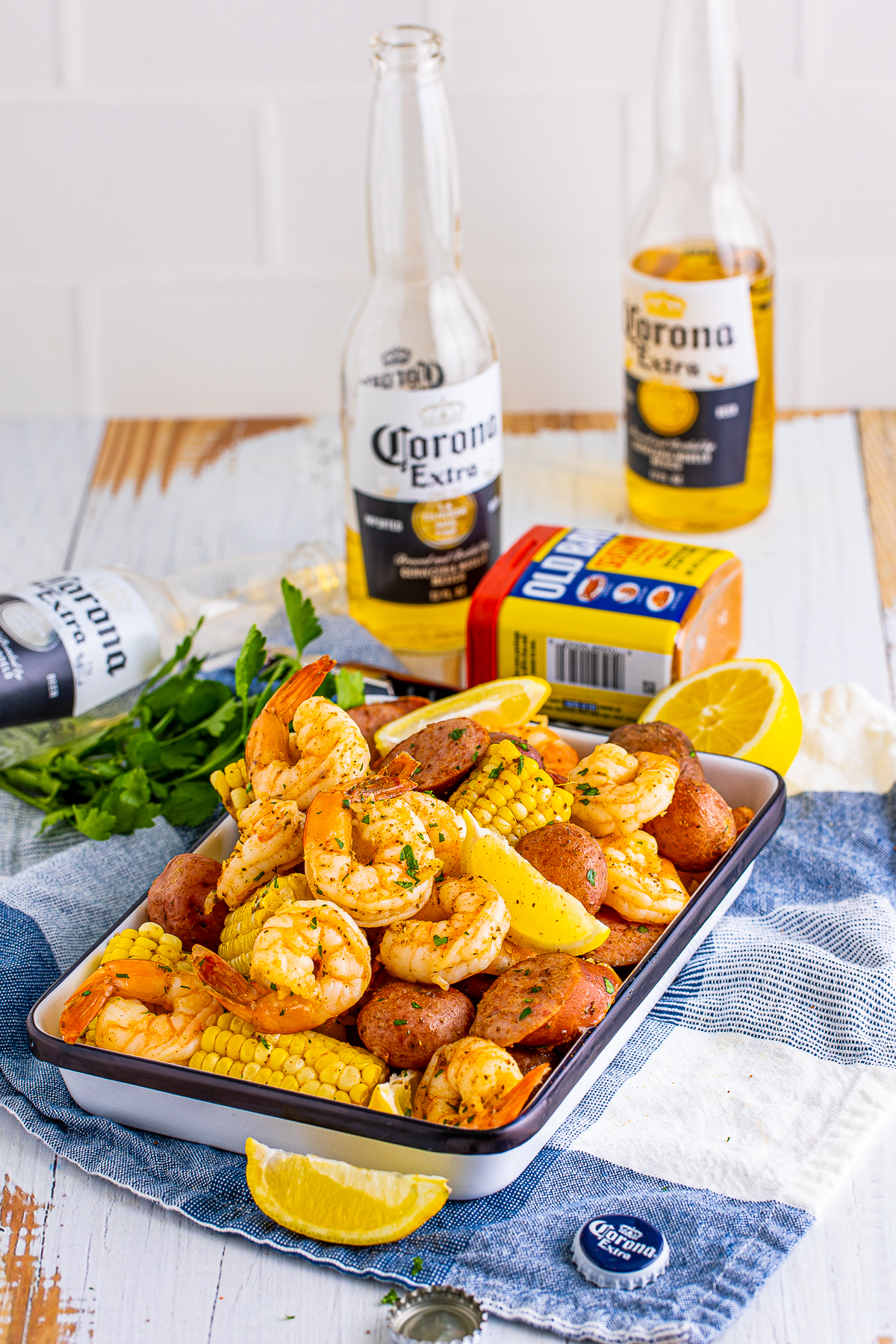 Shrimp Boil on metal gray with beer and old bay in background.