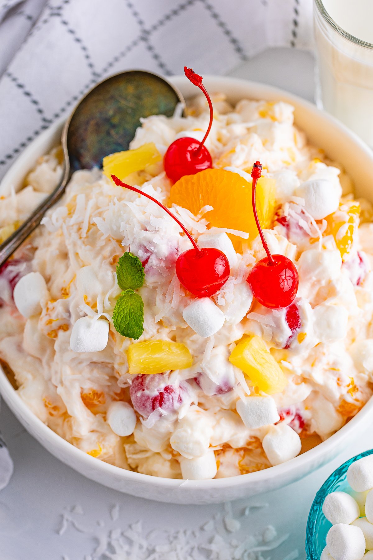 Overhead photo of Ambrosia Salad Recipe showing ingredients topped with cherries.rosia Salad 