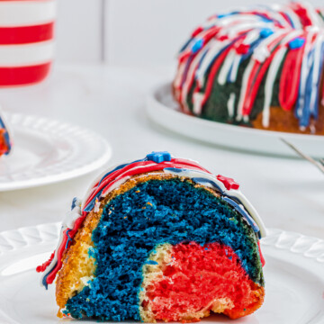 Slice of Patriotic Bundt Cake on white plate with whole cake in background.