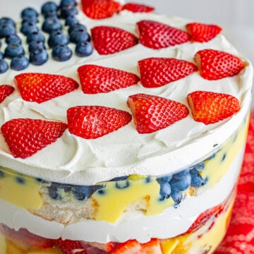 A 4th of July Trifle in a glass bowl topped with a blueberry and strawberry flag design.