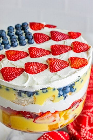 A 4th of July Trifle in a glass bowl topped with a blueberry and strawberry flag design.