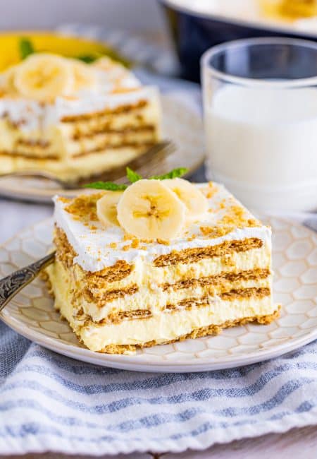 Slice of Banana Icebox Cake on plate with toppings.