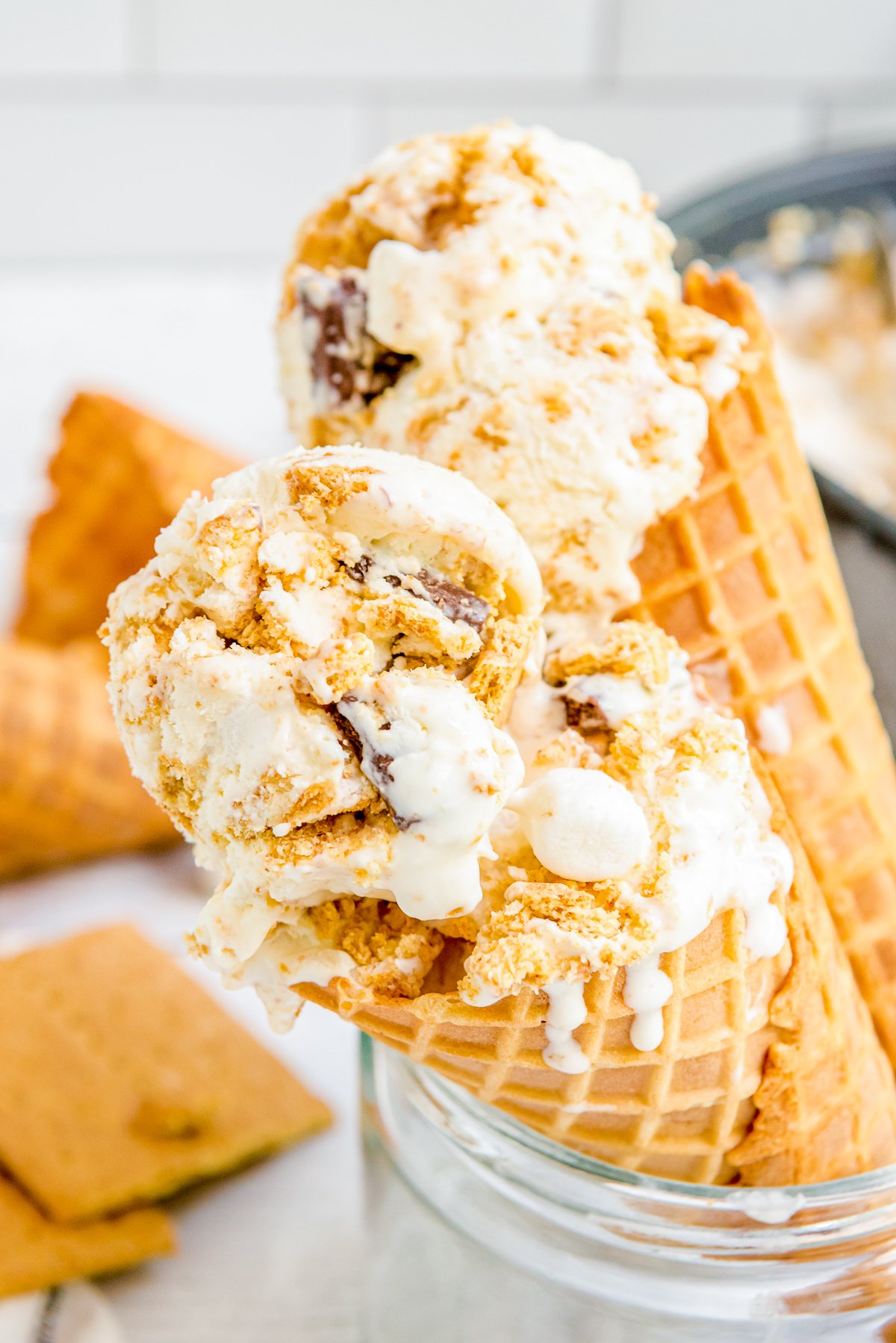 Two ice cream cones filled with ice cream.
