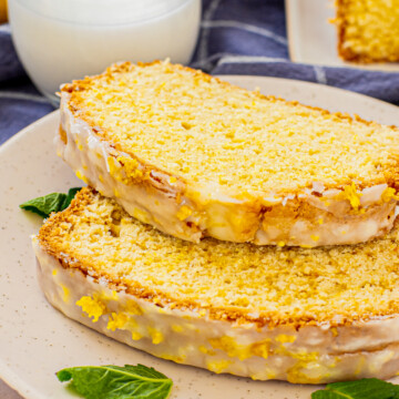 Close up side view of two slices of stacked Lemon Bread on white plate.